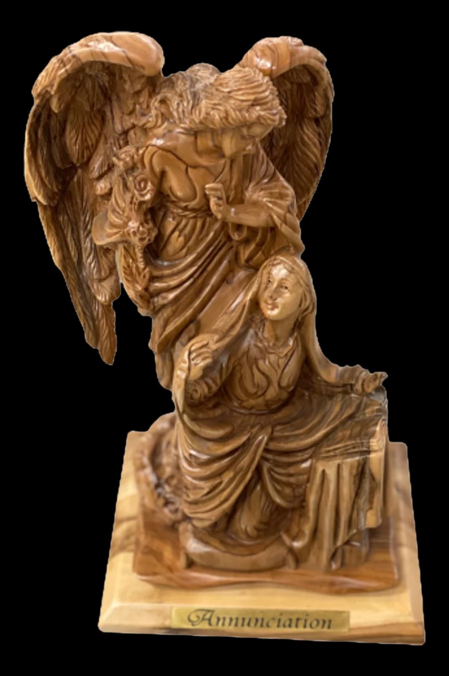 Olive wood carving of the angel Gabriel with large wings above the kneeling Virgin Mary