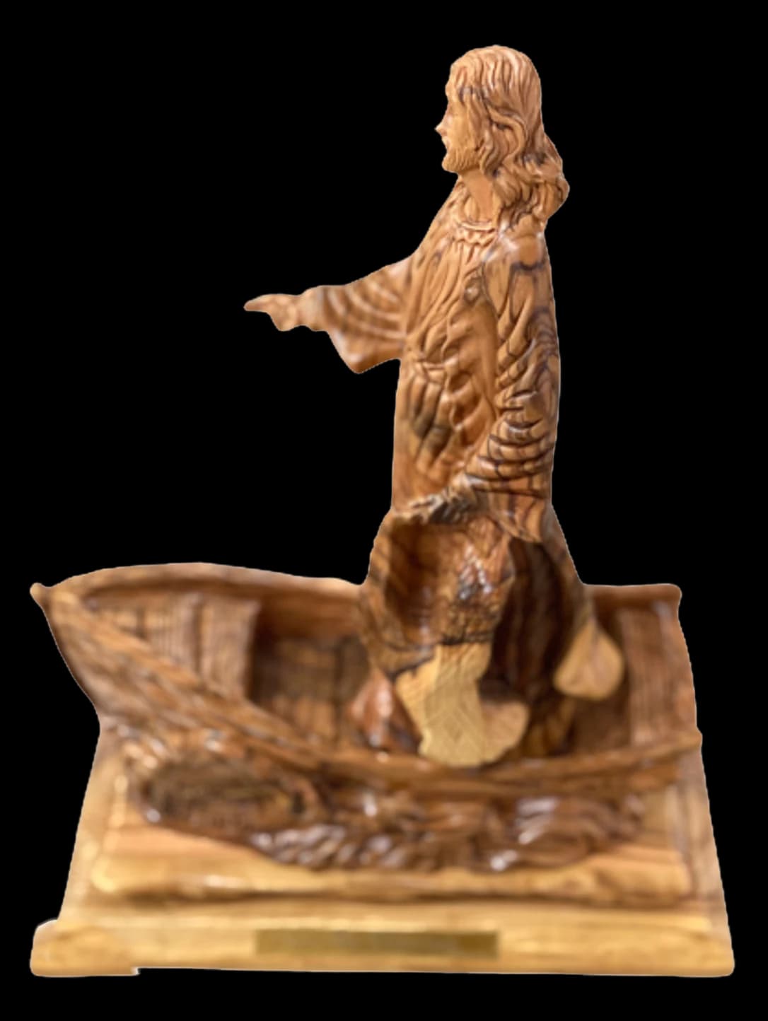 Olive wood carving of Christ standing beside a fishing boat with an arm outstretched